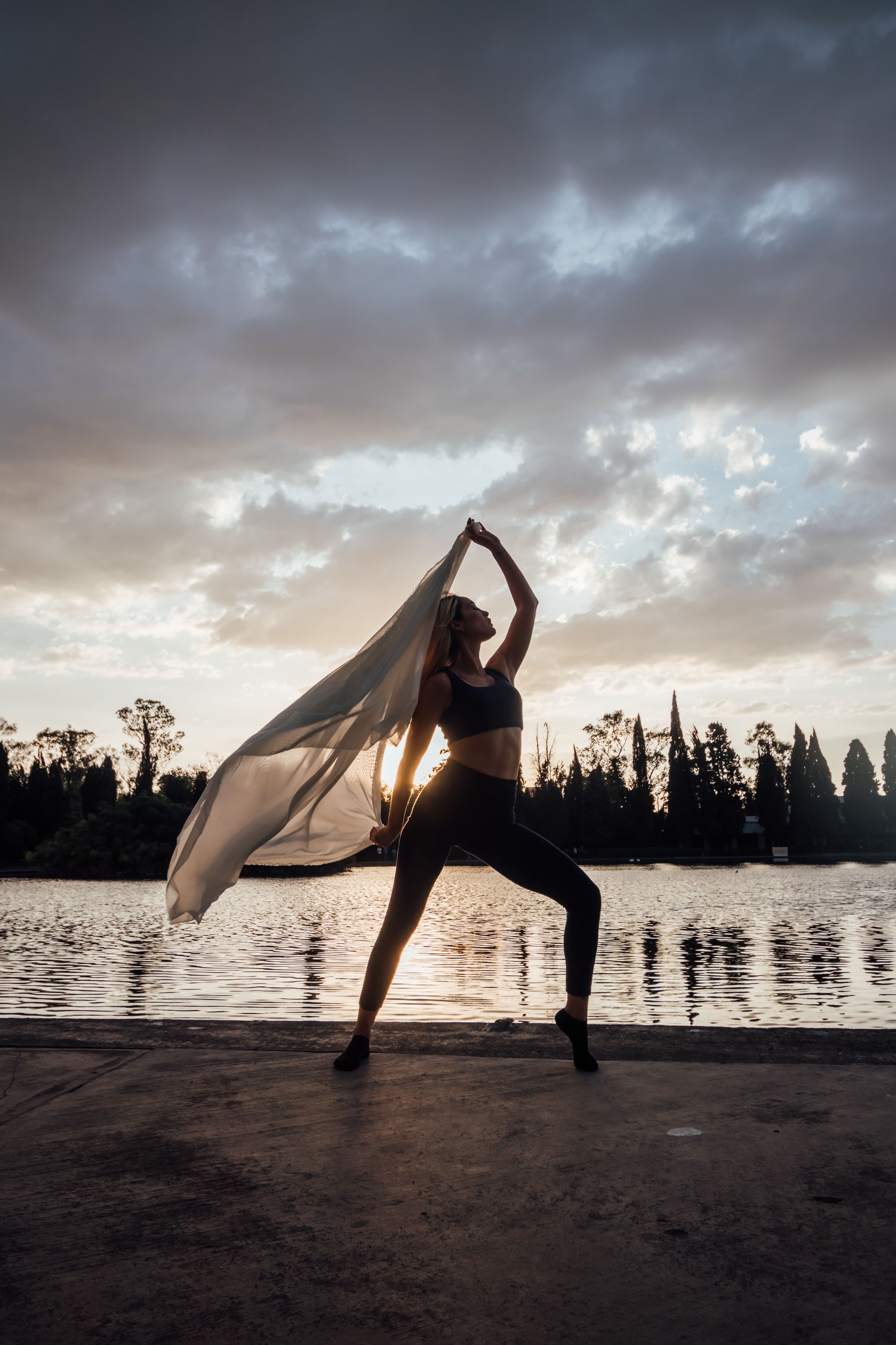 Woman Posing near Water at Sunset · Free Stock Photo