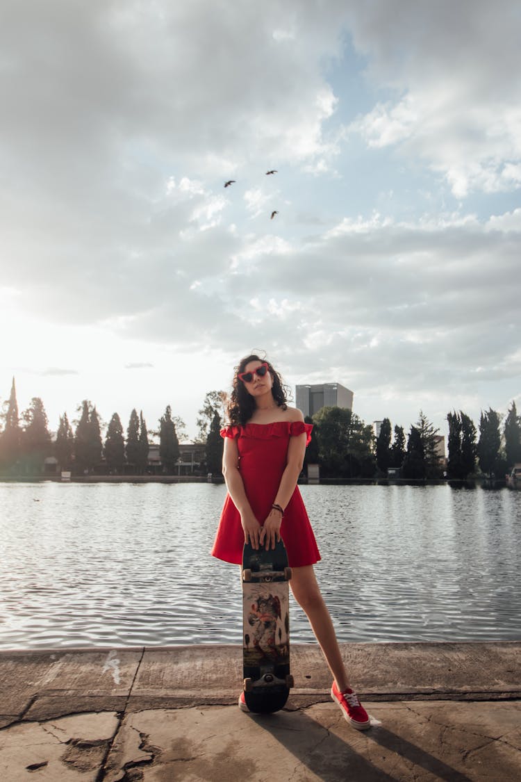 Woman In Off Shoulder Dress Holding A Skateboard