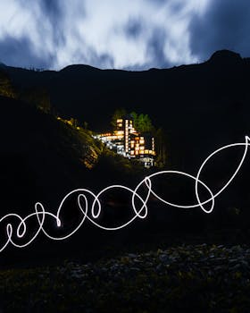 Stunning architecture set against a mountainous backdrop in India with neon light trails at night.