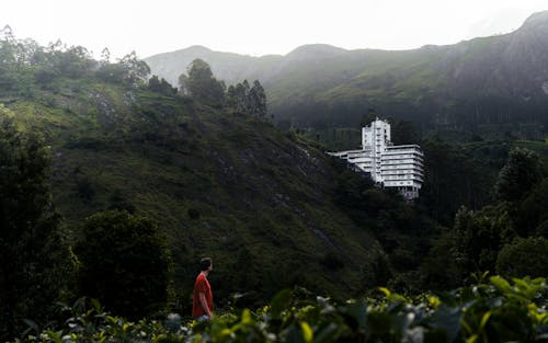 Man Looking at the White Building on the Mountain