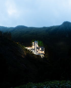 A stunning modern building illuminated at dusk in an Indian mountain setting.