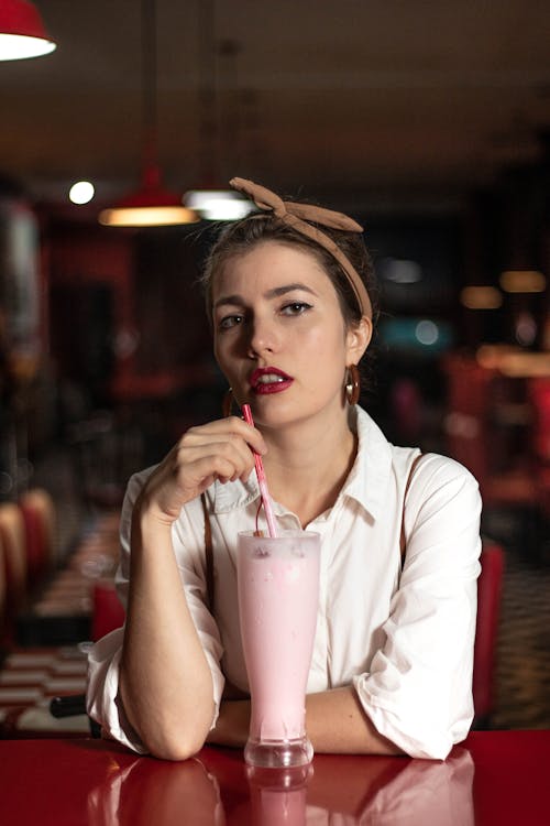 Woman Holding a Red Drinking Straw 