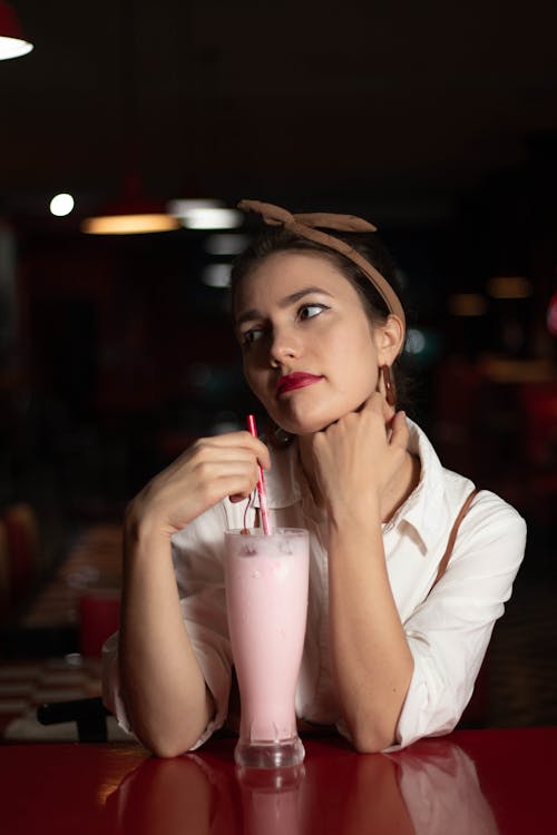 Woman Holding a Red Drinking Straw