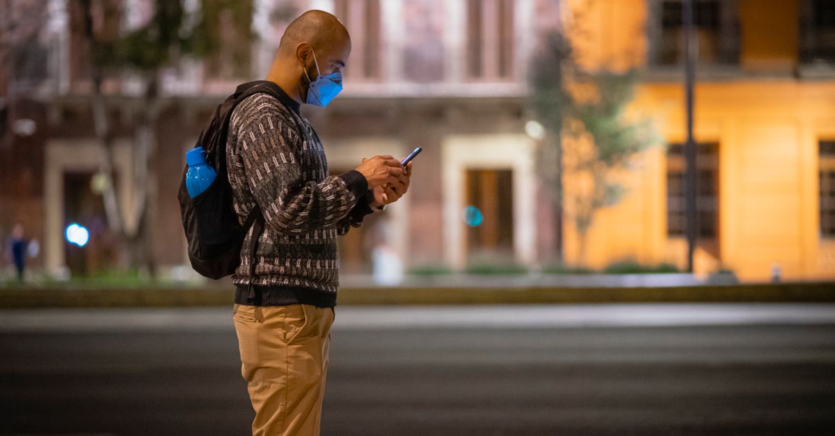 Hispanic man sending money online with smartphone to family in latin america