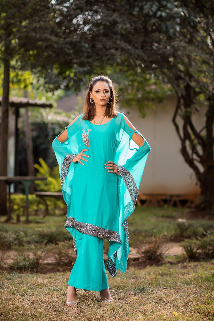 Woman Wearing A Teal Dress Posing On Green Grass