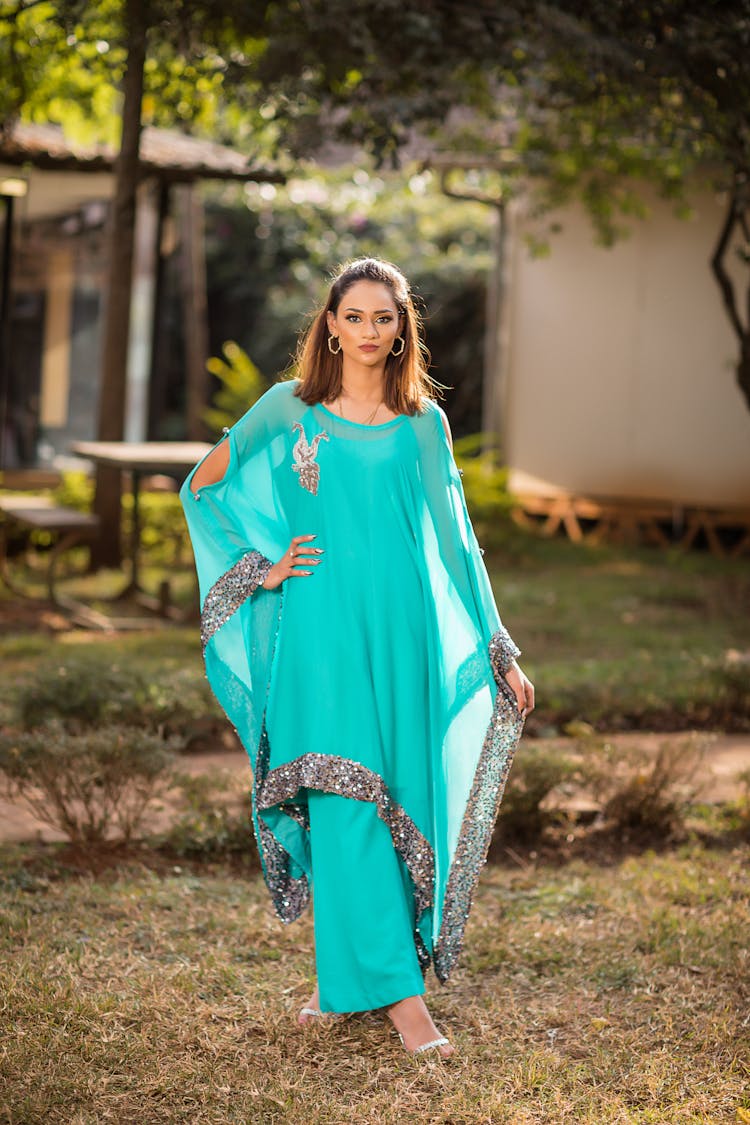 Woman In Teal Long Dress Standing On Brown And Green Grass