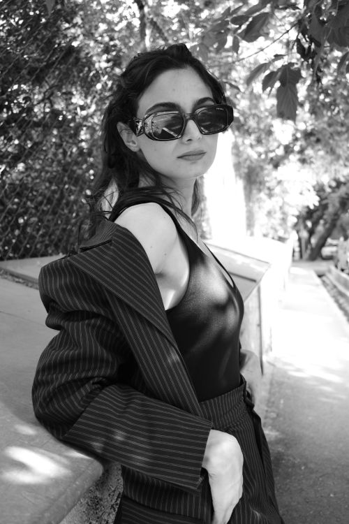 Free A fashionable woman poses outdoors with stylish sunglasses in a monochrome setting. Stock Photo
