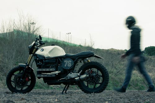 человек, стоящий возле черно белого стандартного мотоцикла Bmw