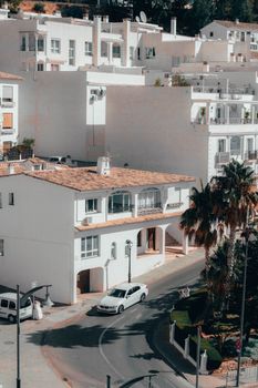 A picturesque aerial view of white Mediterranean villas with palm trees on a sunny day, showcasing elegant architecture.