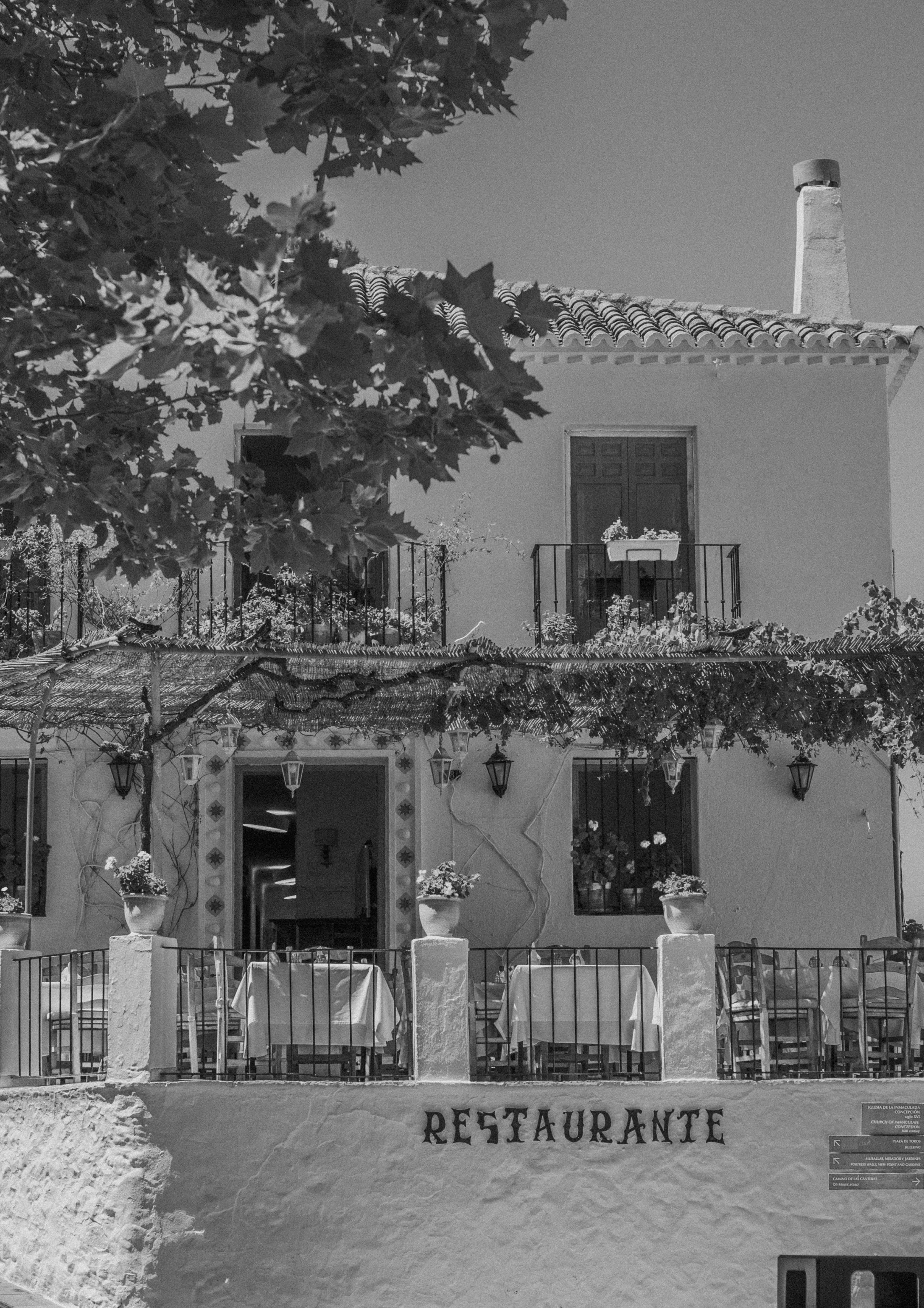 Black and white photo of a quaint Spanish restaurant with balconies.