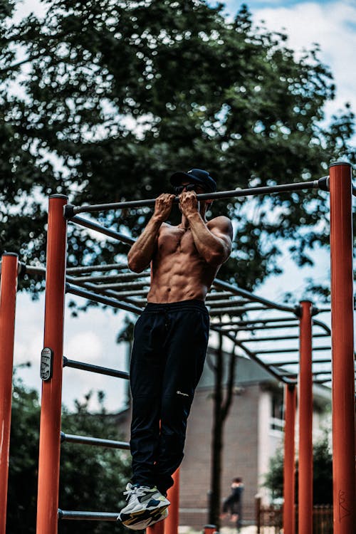 Free Muscular Man Training on Bar Outdoors Stock Photo