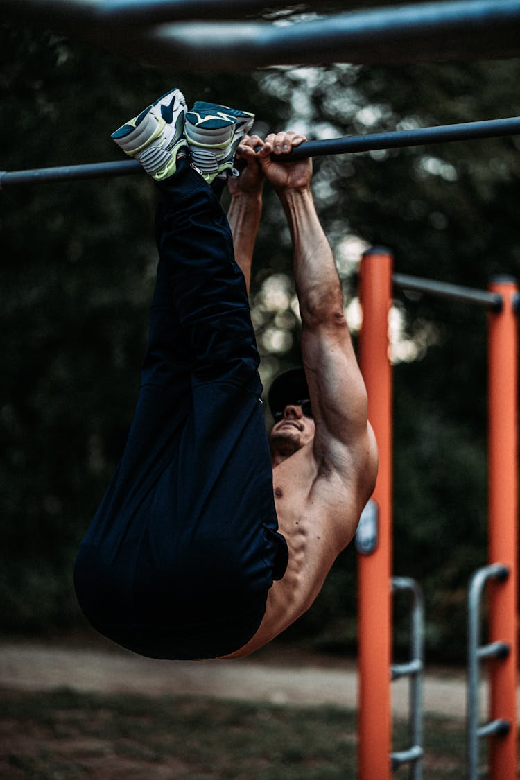 Toned Man Training On Bar Outdoors