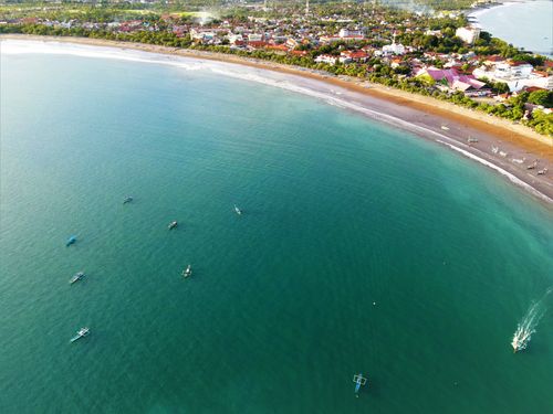 Free Drone shot capturing the coastline and boats along Pangandaran Beach in Indonesia. Stock Photo
