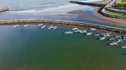 Free Scenic aerial view of fishing boats docked at Pangandaran Harbor, Java, Indonesia. Stock Photo