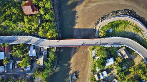 Free A stunning aerial view of a bridge surrounded by lush tropical scenery in Pangandaran, Indonesia. Stock Photo