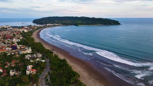 Free Stunning aerial view of Pangandaran Beach, Indonesia's coast with serene ocean waves and lush greenery. Stock Photo