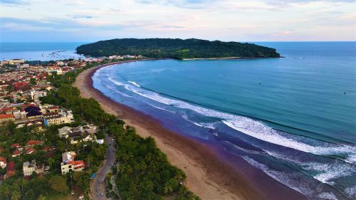 Free Stunning aerial shot of Pangandaran Beach showcasing shoreline, waves, and lush greenery. Stock Photo