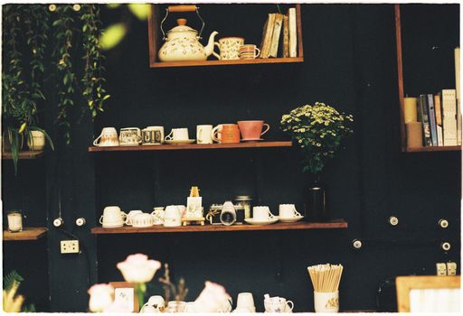 Cozy café interior featuring rustic shelves with teapots, cups, and decor elements.