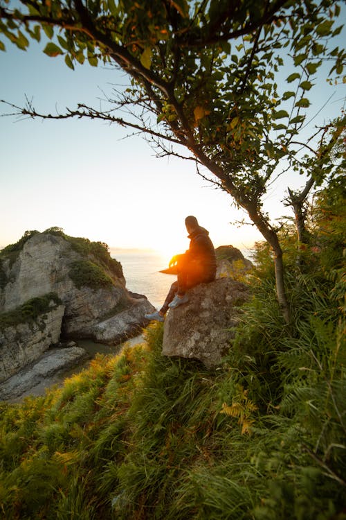 A Man Sitting on a Rock during the Golden Hour