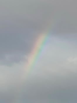 A stunning rainbow arcs across a cloudy sky, capturing natural beauty and weather phenomenon.
