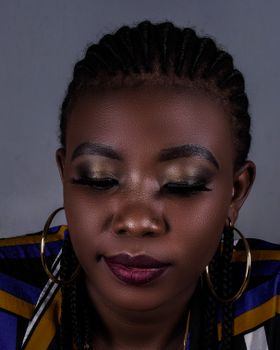 Graceful portrait of a woman with braided hair and subtle makeup, showcasing elegance.