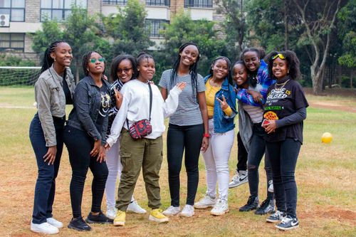 Free A cheerful group of young adults posing together outside on a bright day. Stock Photo