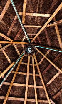 Detailed view of a rustic thatched roof ceiling with wooden planks, showcasing traditional architecture in Lagos, Nigeria.