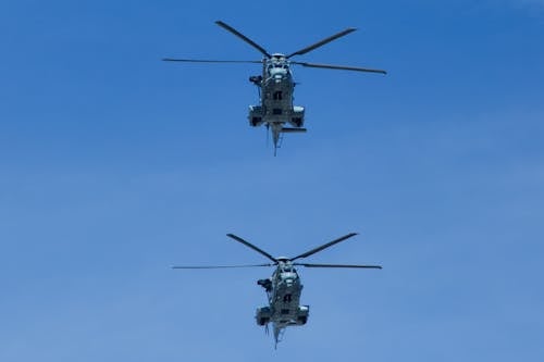 Helicopters Flying Under Blue Sky
