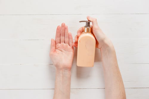 A Person Using Lotion in a Pump Bottle