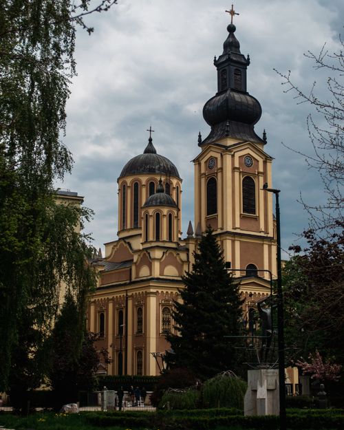Free A historic Orthodox cathedral in Sarajevo, Bosnia, framed by lush trees under a cloudy sky. Stock Photo