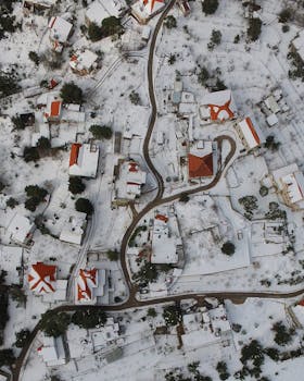 Snow-covered rooftops and landscape in Zabbougha, Lebanon from an aerial perspective.