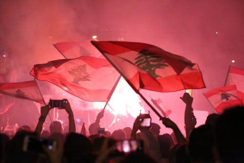 A Crowd Gathered in a Concert Waving Flags