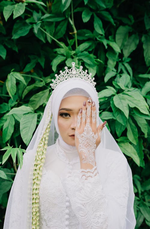 Free Bride in a Traditional White Dress Covering her Face with a Hand Stock Photo