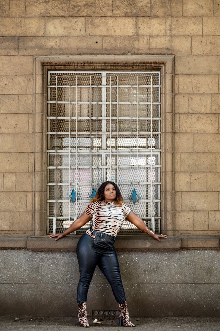 Woman Posing By Building Window And Wall