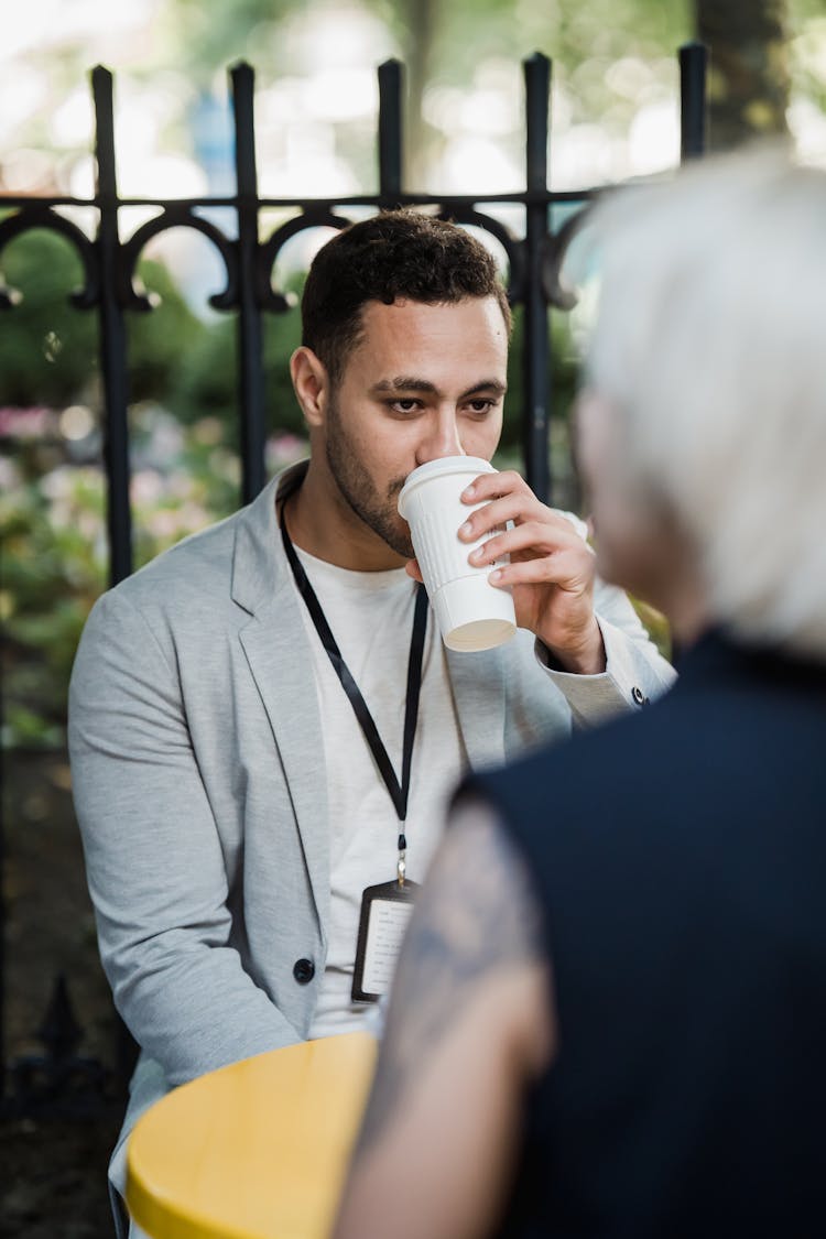 Man Drinking Coffee By Yellow Table