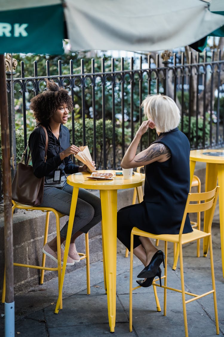 Couple Talking By Outdoor Cafe Table