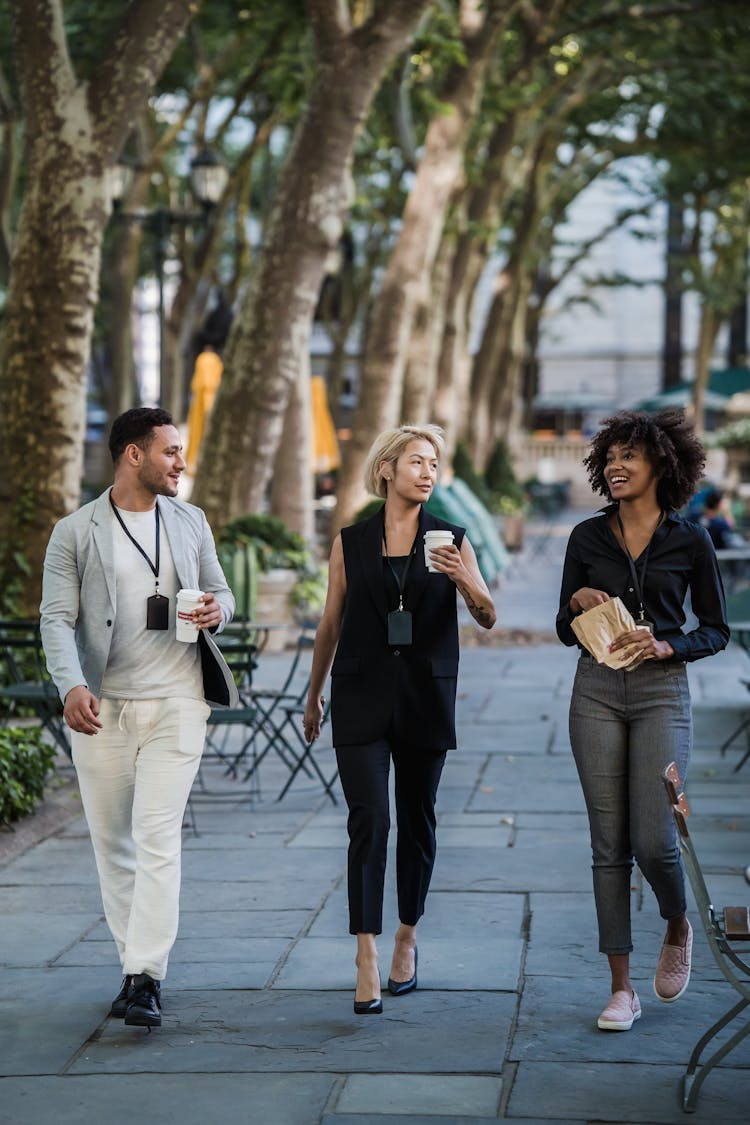 Group Of Friends Walking Through Street With Takeout