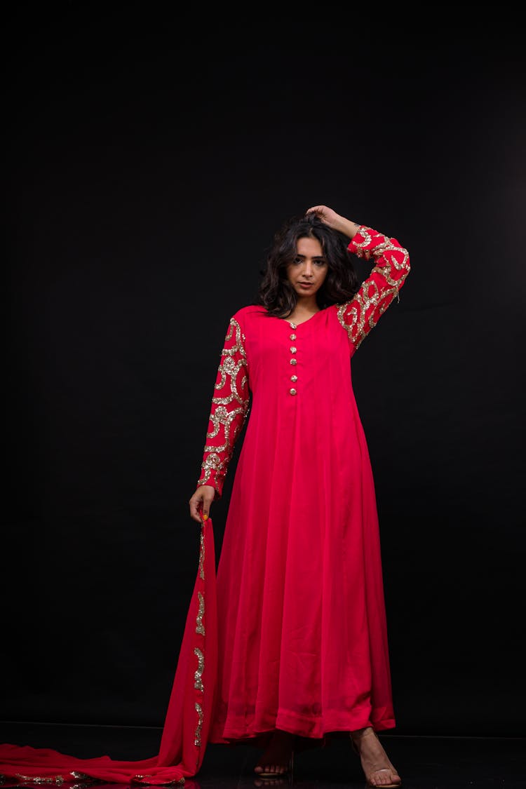 Photo Of A Woman In A Red Dress Against A Black Background 