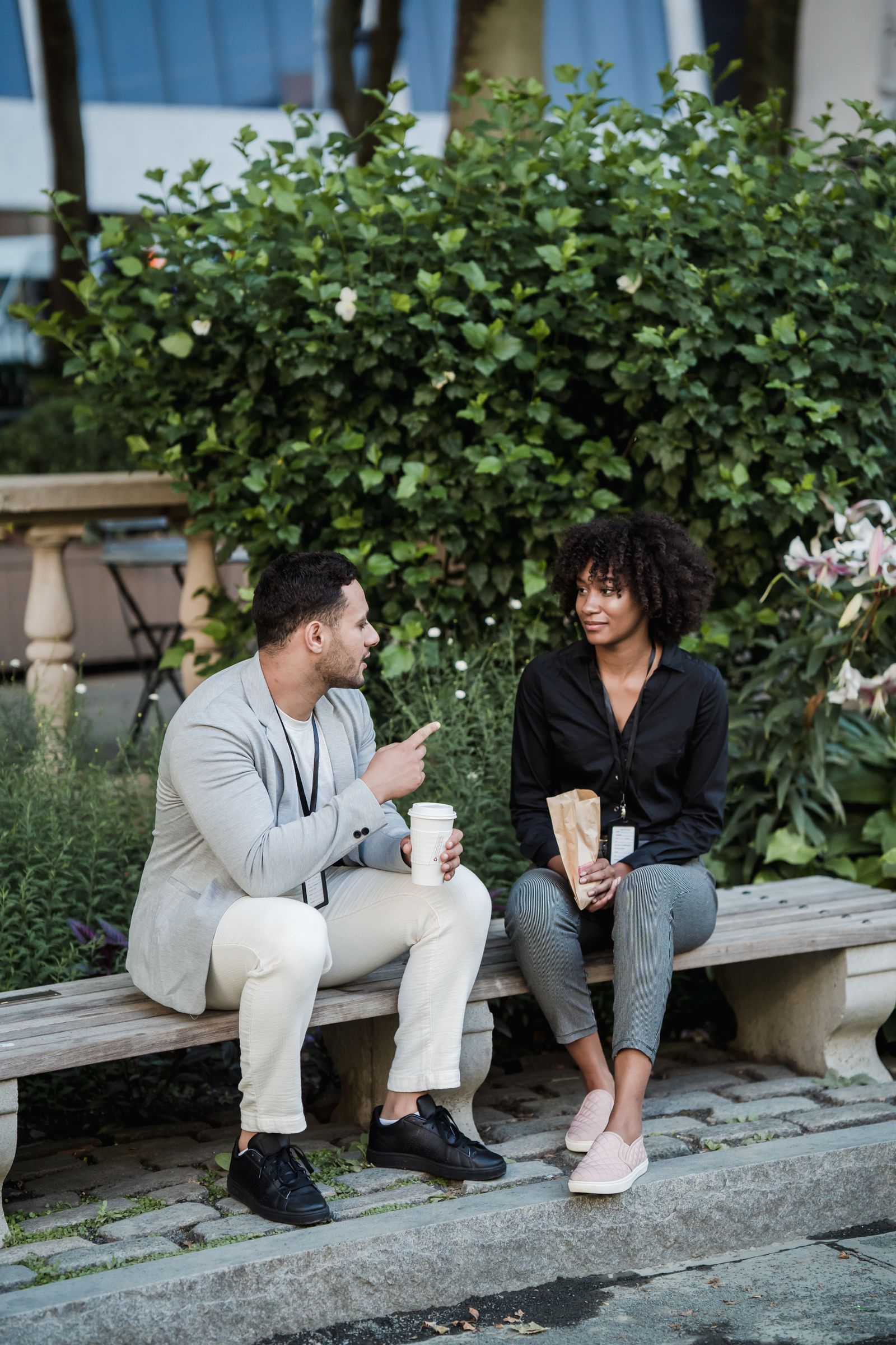 Two people talking together on a park bench