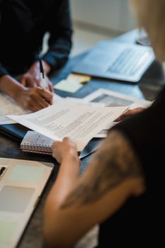 Two professionals collaborate on document reviews in a modern office.