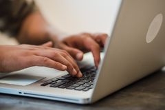 Adult typing on a laptop keyboard indoors, focused on work and technology.