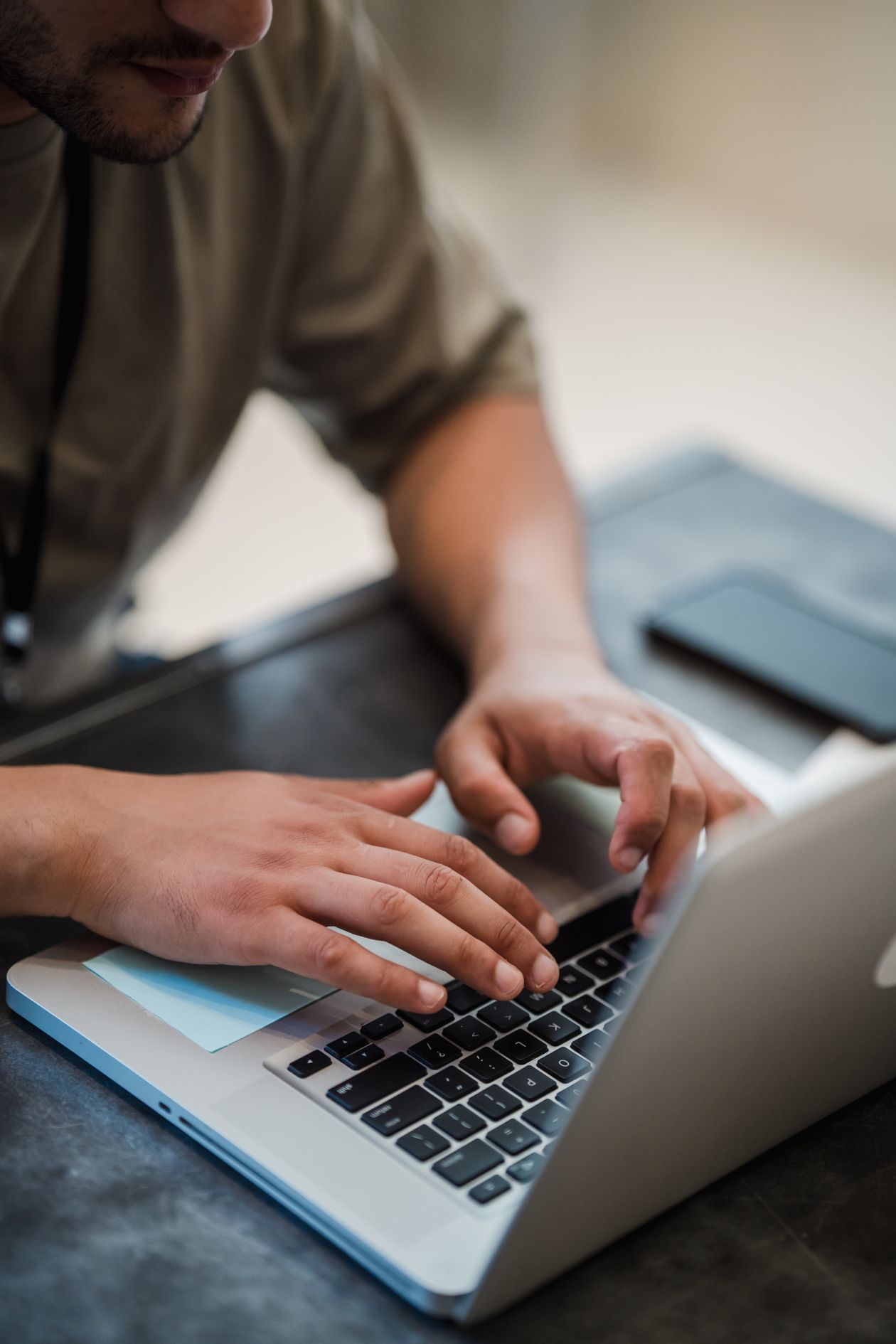 Close-up of hands typing on a laptop, representing a faceless AI side hustle where identity stays hidden