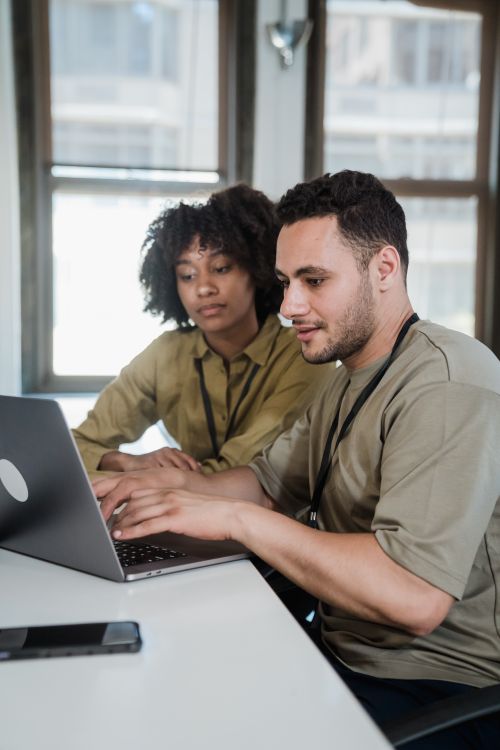 Free Two colleagues working collaboratively on a laptop in an office. Stock Photo