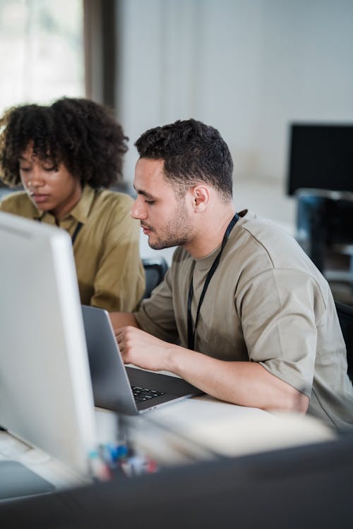 Vertical Shot of Man and Woman Using Computers at Desk