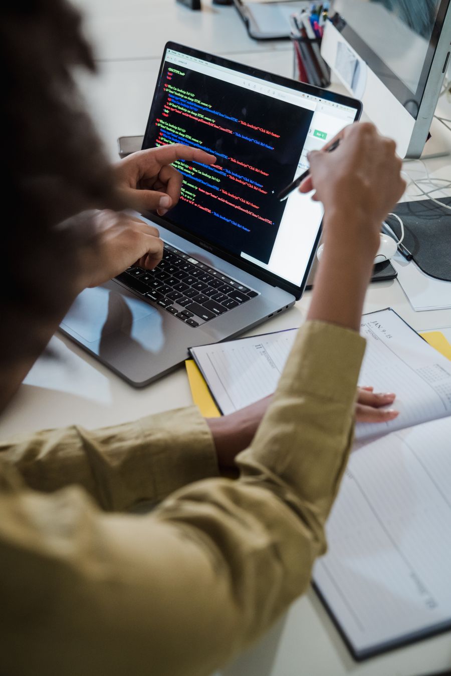 Two developers discussing code on a laptop