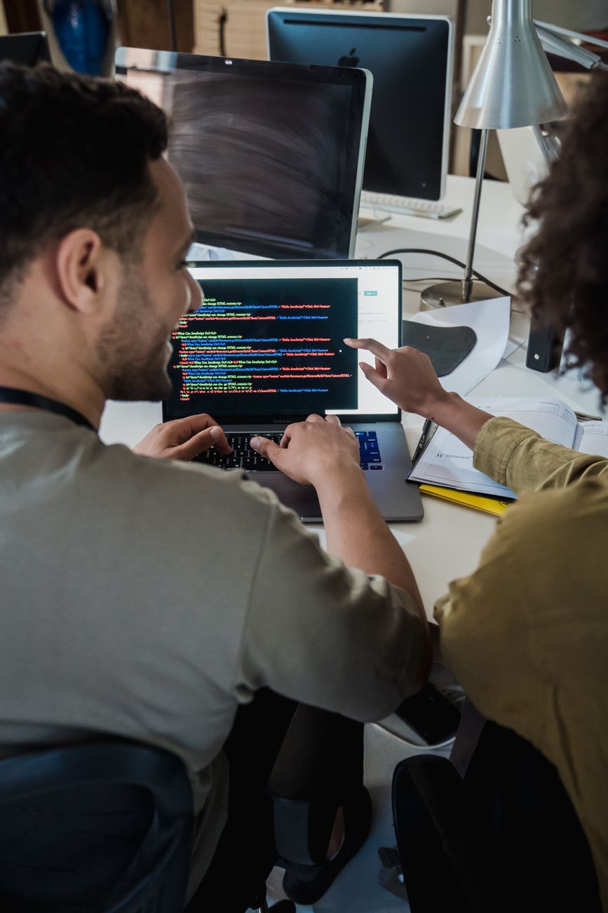 Development team collaborating on pull request review on laptop screens