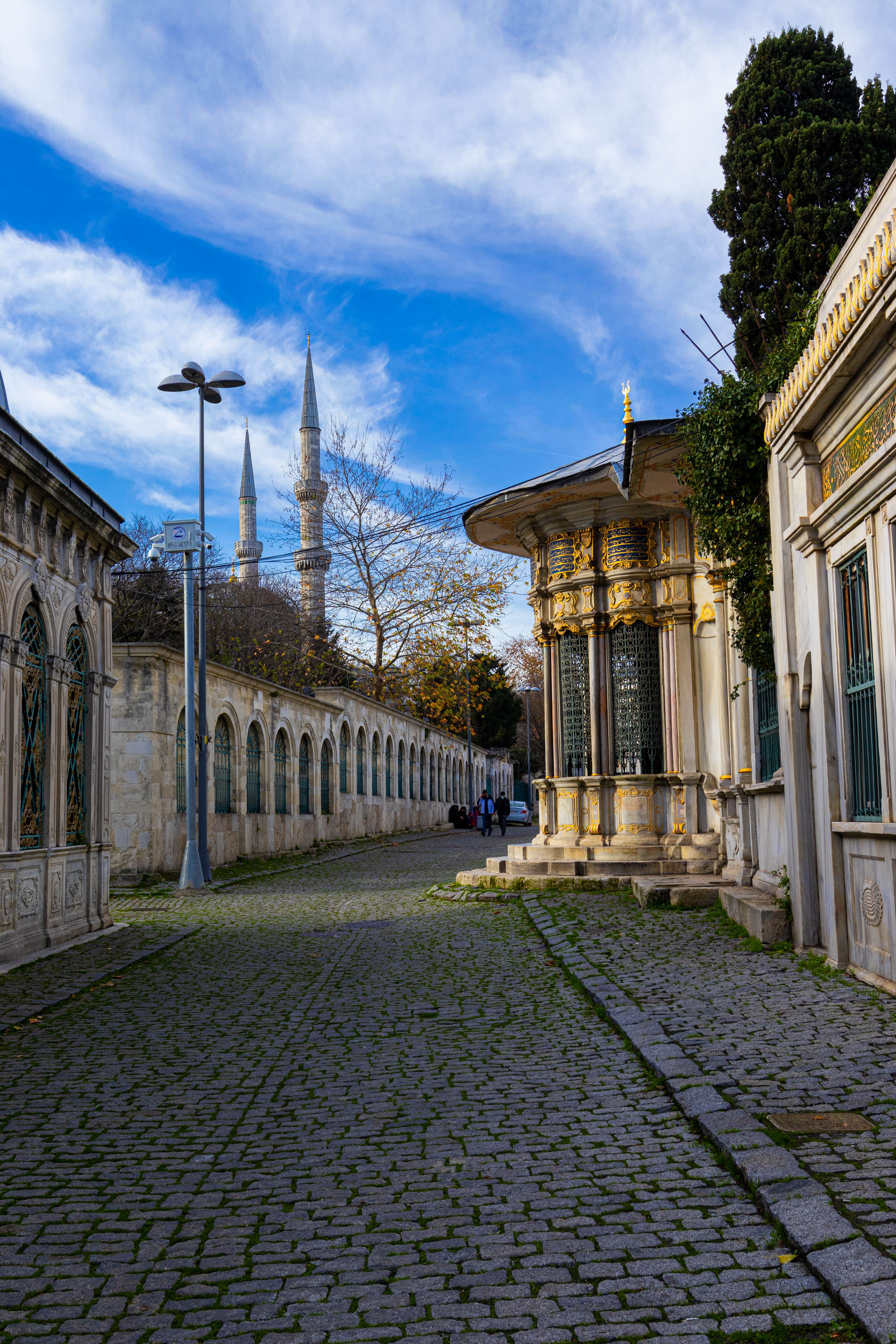 A picturesque cobblestone street with minarets in the background near Eyüp Sultan Mosque in Istanbul, Turkey.