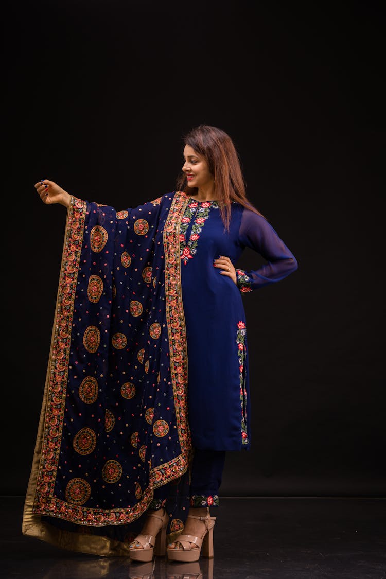 Woman In Elegant Traditional Costume Posing In Black Studio