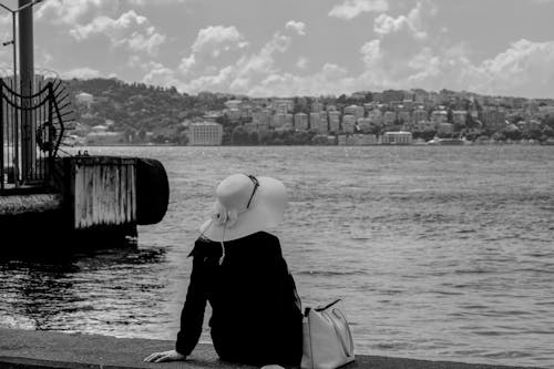 Foto d'estoc gratuïta de assegut, barret, blanc i negre