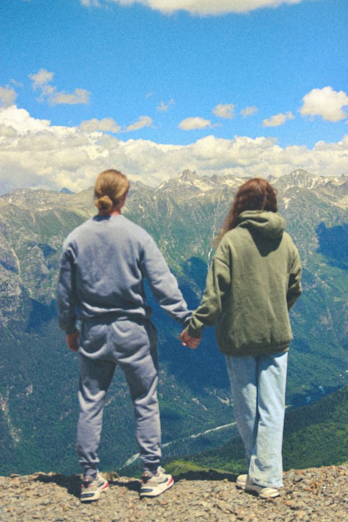 Free A Couple Holding Hands Looking at Mountains Stock Photo